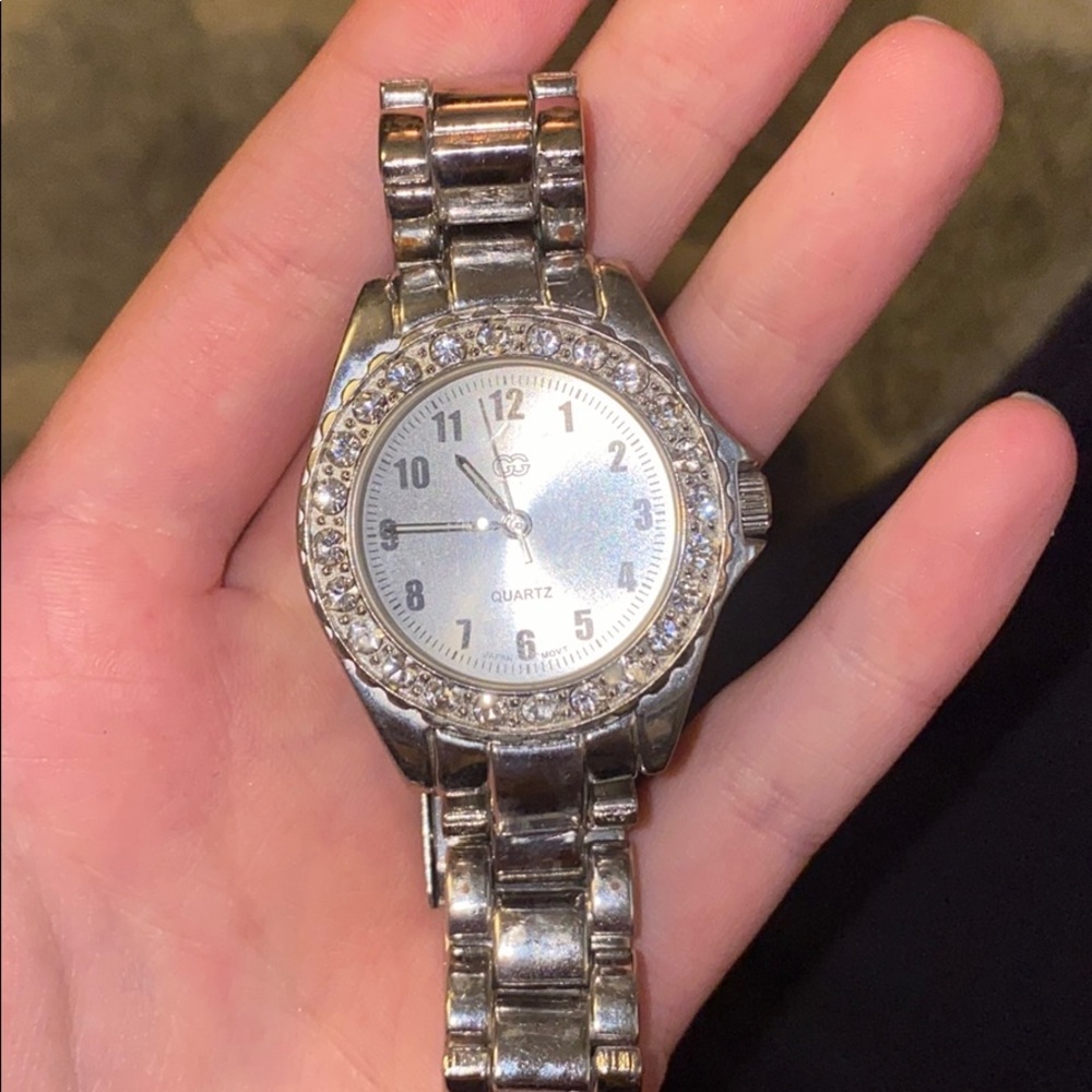Silver watch with crystals bordering it